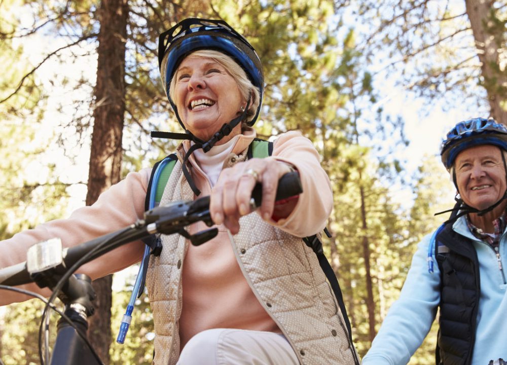 Senior couple mountain biking on a forest trail