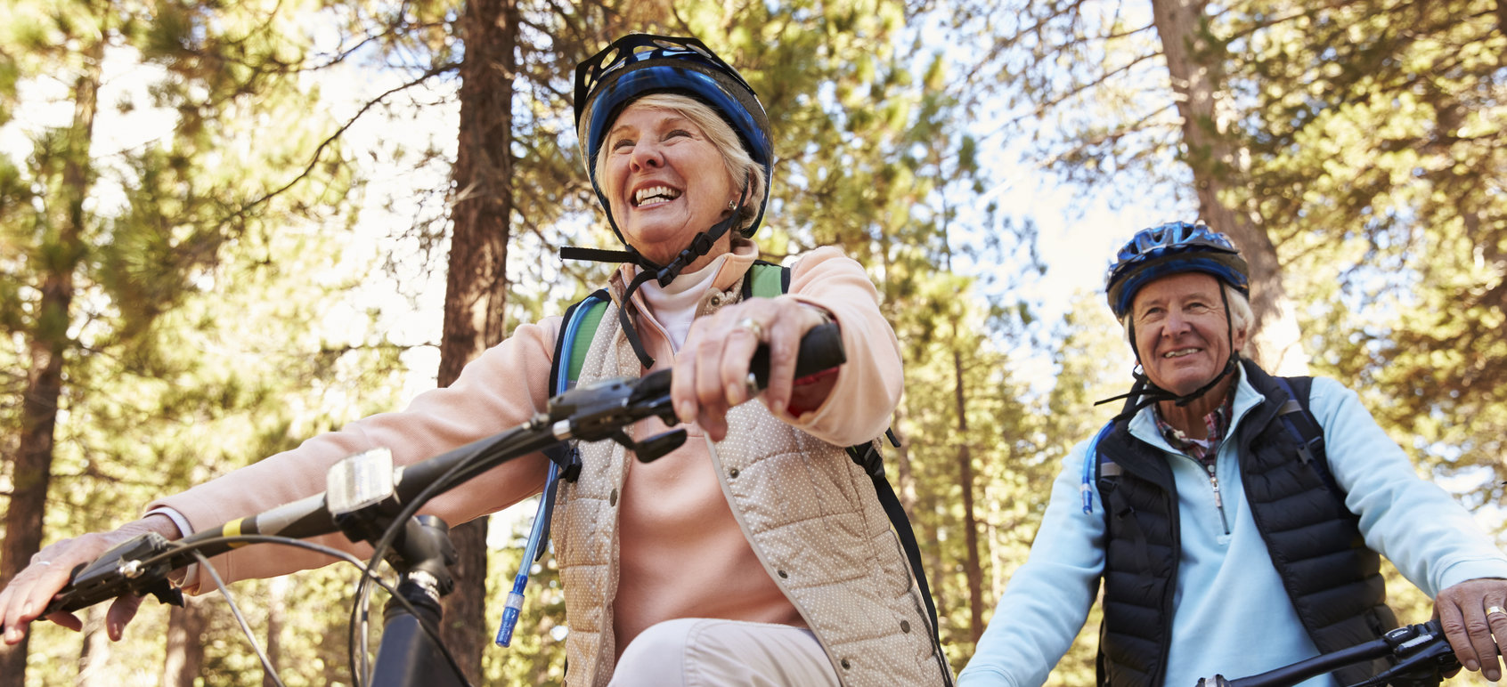 Senior couple mountain biking on a forest trail